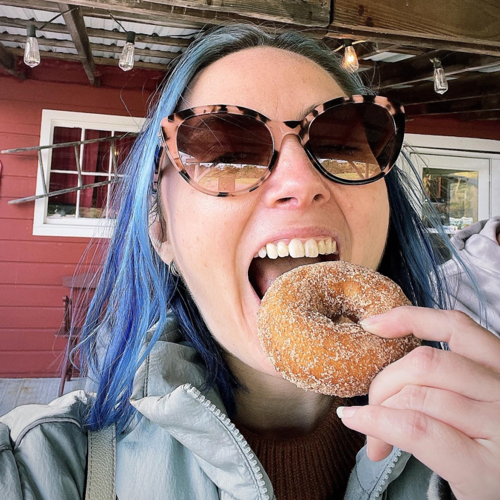 Brooke biting into an apple cider donut